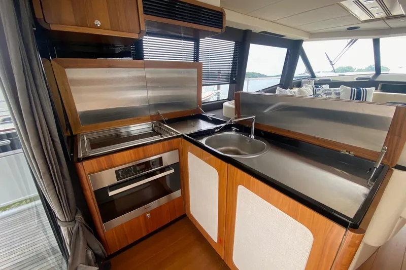 Slide: The Image of Modern kitchen interior on 2014 Azimut Magellano 50 yacht, featuring sleek wood and stainless steel design. - 16
