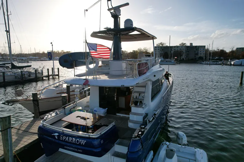 Slide: The Image of Azimut Magellano 50 yacht docked, 2014 model, with American flag, in marina setting. - 2