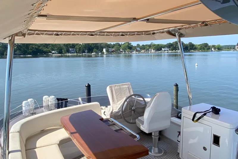 Slide: The Image of Azimut Magellano 50 yacht deck, 2014 model, with seating and steering area overlooking serene waters. - 4