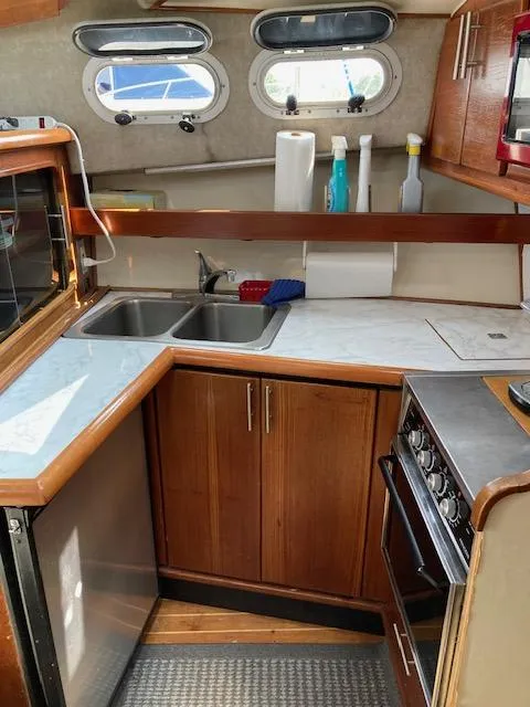 Slide: The Image of 1990 Bayliner 3288 Motoryacht kitchen with sink, stove, and storage cabinets. - 11