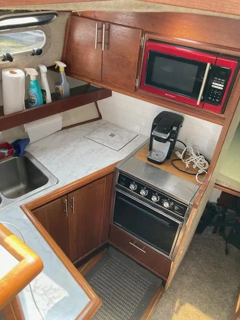 Slide: The Image of 1990 Bayliner 3288 Motoryacht kitchen with microwave, stove, and sink. - 6
