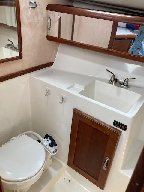 Slide: The Image of 1990 Bayliner 3288 Motoryacht bathroom with sink, toilet, and storage cabinet. - 8