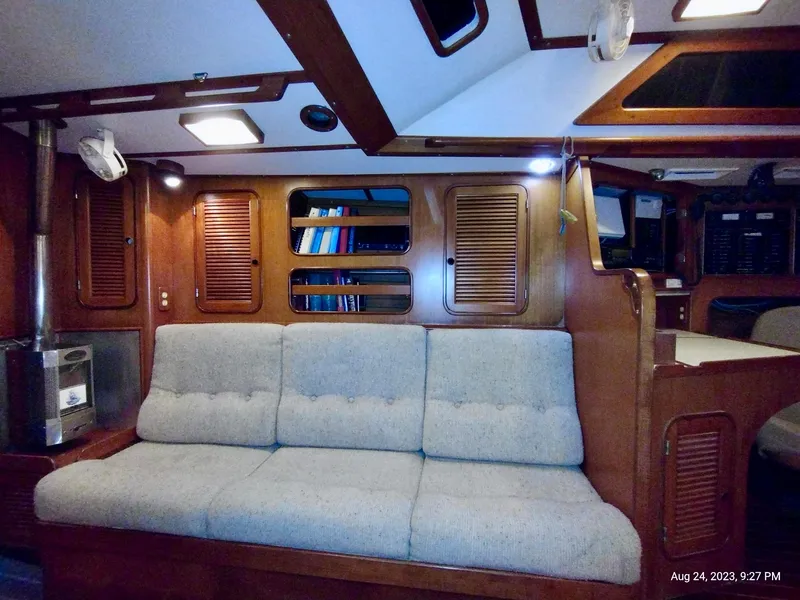 Slide: The Image of Interior of 1983 Norseman 447 CC Cutter with cozy seating and wooden cabinetry. - 10