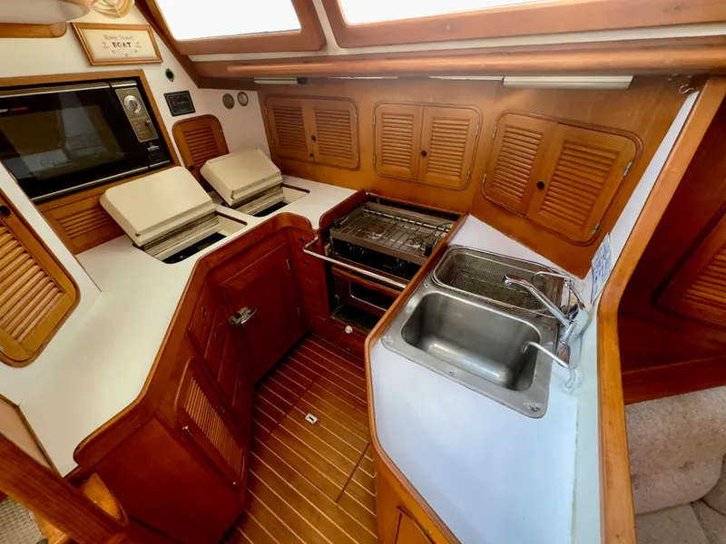 Slide: The Image of 1983 Norseman 447 CC Cutter yacht kitchen with wood cabinetry, stove, and sink. - 13