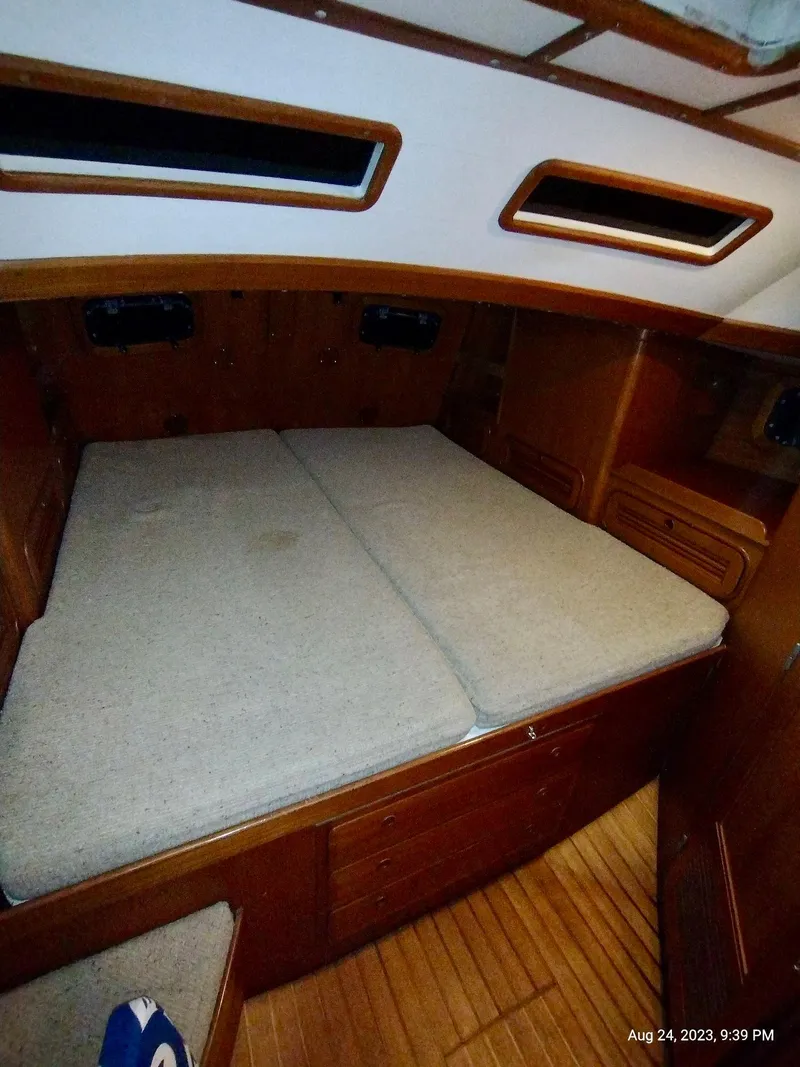 Slide: The Image of Interior cabin of 1983 Norseman 447 CC Cutter with wooden finish and cozy bedding. - 17