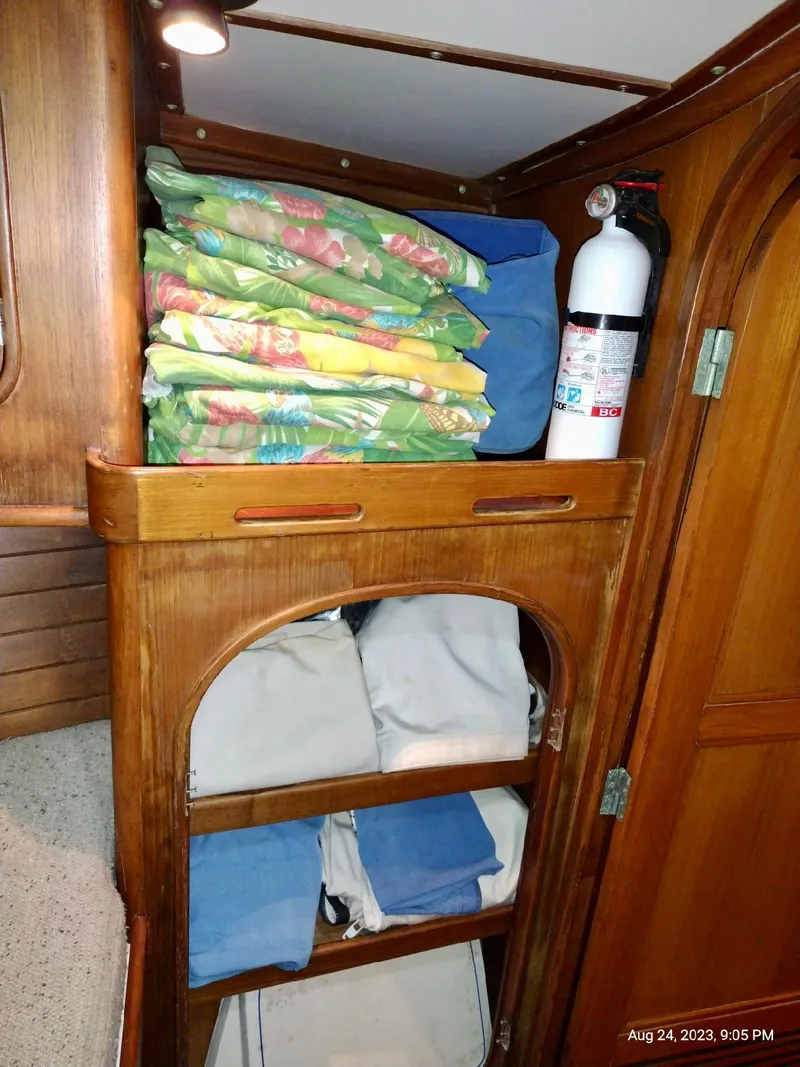 Slide: The Image of Wooden cabinet in 1983 Norseman 447 CC Cutter with linens and fire extinguisher. - 24