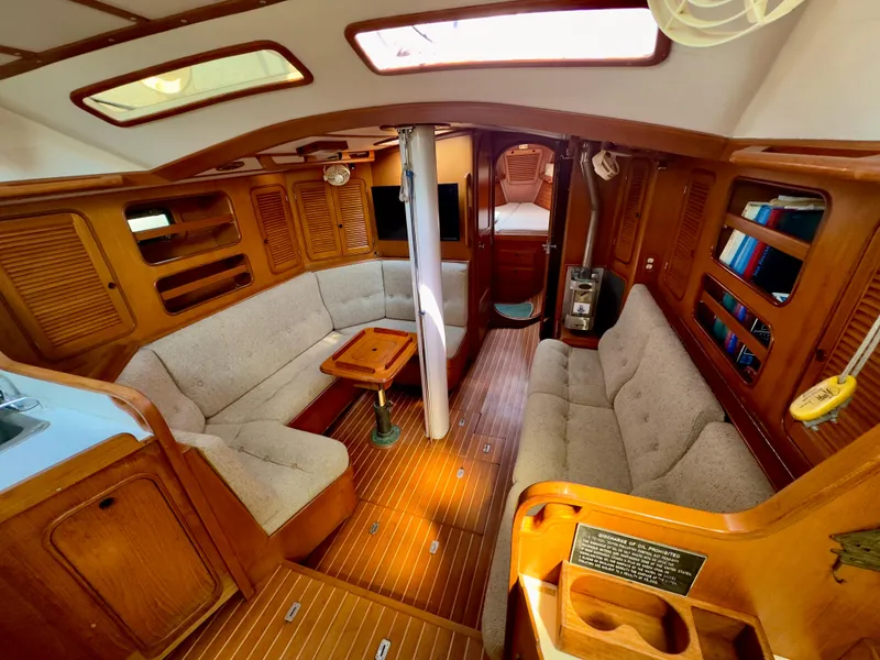 Slide: The Image of Interior of 1983 Norseman 447 CC Cutter sailboat with wooden finish and cozy seating. - 8
