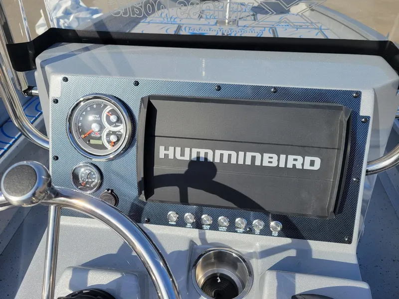 Slide: The Image of 2024 Xpress X23 Bay Lounge dashboard with Humminbird display and gauges. - 11