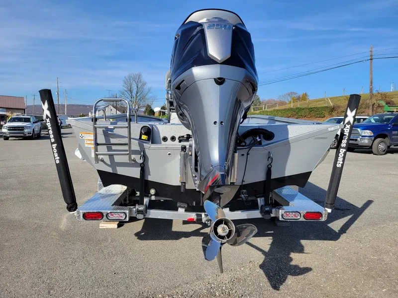 Slide: The Image of 2024 Xpress X23 Bay Lounge boat with powerful outboard motor, parked outdoors. - 13