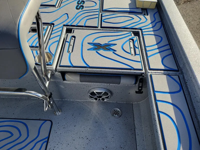 Slide: The Image of 2024 Xpress X23 Bay Lounge boat interior with stylish blue accents and speaker system. - 17