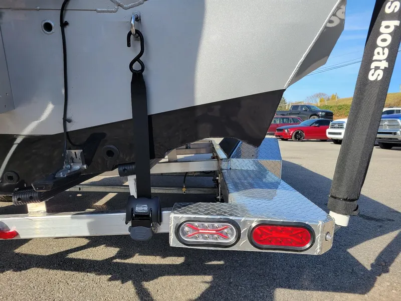 Slide: The Image of 2024 Xpress X23 Bay Lounge boat trailer with secure strap and rear lights. - 3