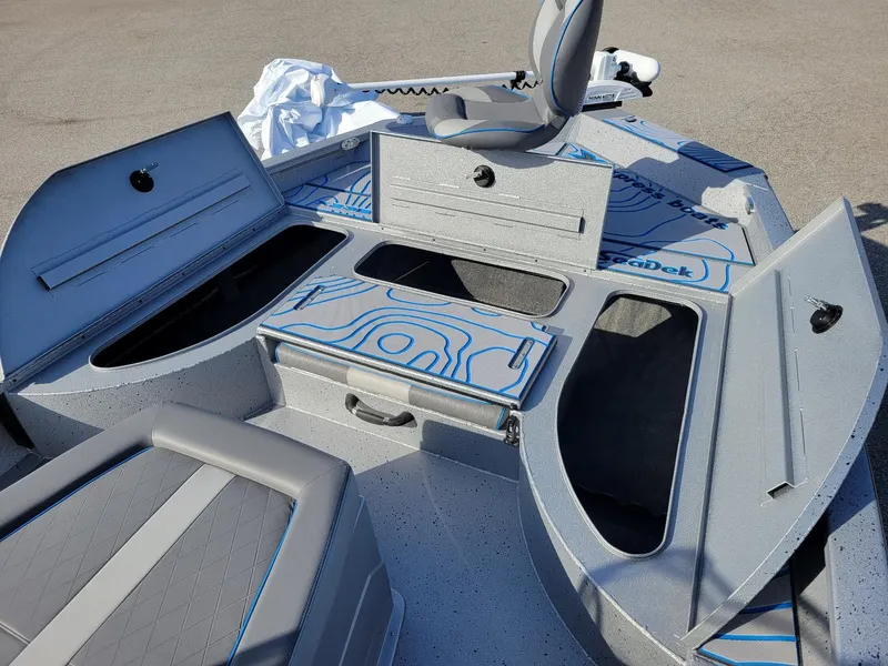 Slide: The Image of 2024 Xpress X23 Bay Lounge boat interior with open storage compartments and seating. - 5