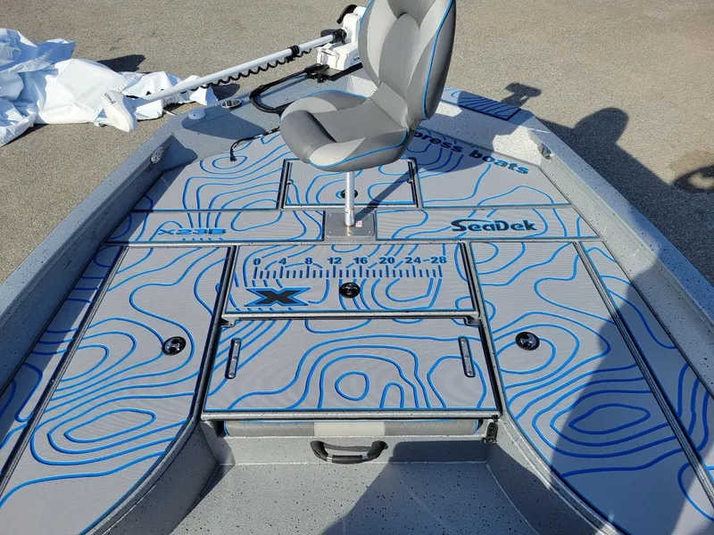 Slide: The Image of 2024 Xpress X23 Bay Lounge boat deck with blue contour design and seating. - 8