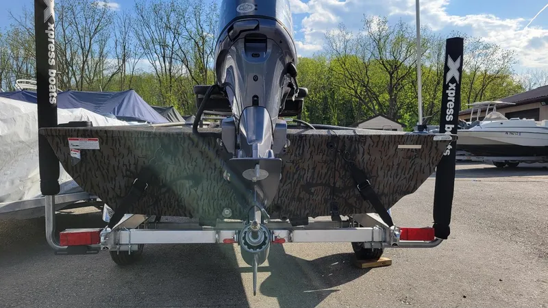 Slide: The Image of 2025 Xpress XP18CC boat with Yamaha 70 hp engine, parked outdoors. - 4