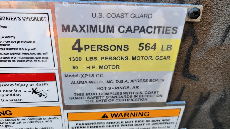 Slide: The Image of U.S. Coast Guard capacity label for 2025 Xpress XP18CC boat, 4 persons, 564 lbs limit. - 7
