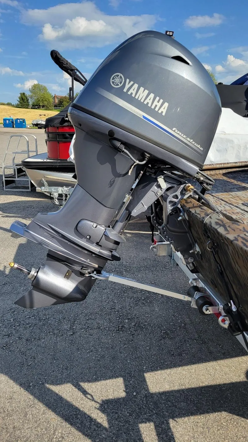 Slide: The Image of 2025 Xpress XP18CC boat with Yamaha 70 hp engine, parked outdoors. - 9