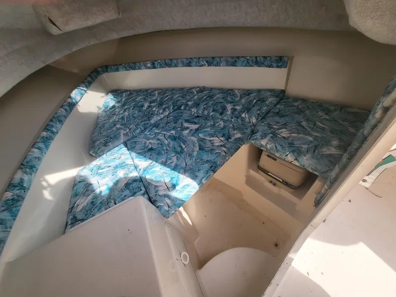 Slide: The Image of 1998 Seaswirl 2300 Walkaround cabin interior with patterned blue cushions. - 13