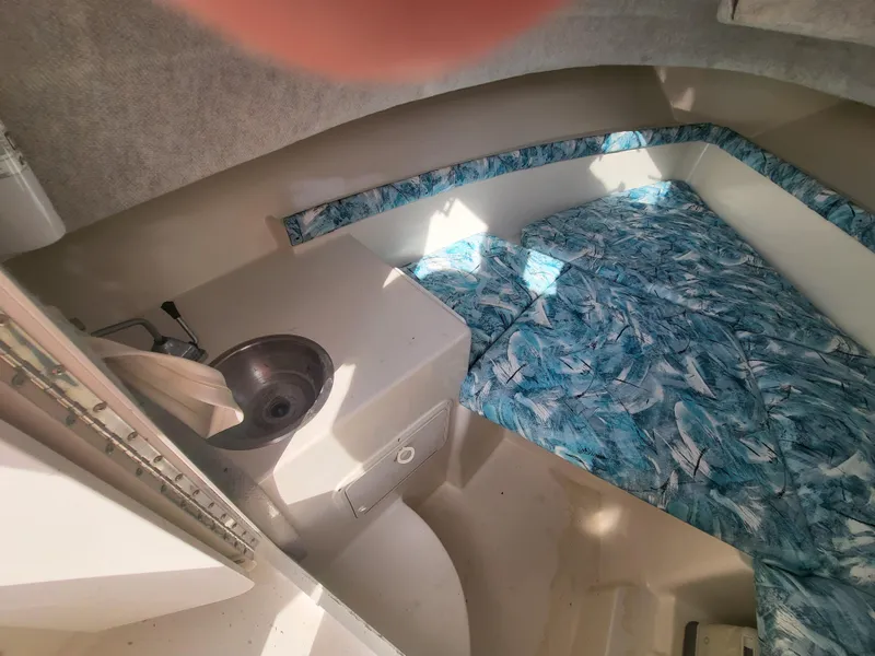 Slide: The Image of 1998 Seaswirl 2300 Walkaround cabin interior with sink and patterned bedding. - 14