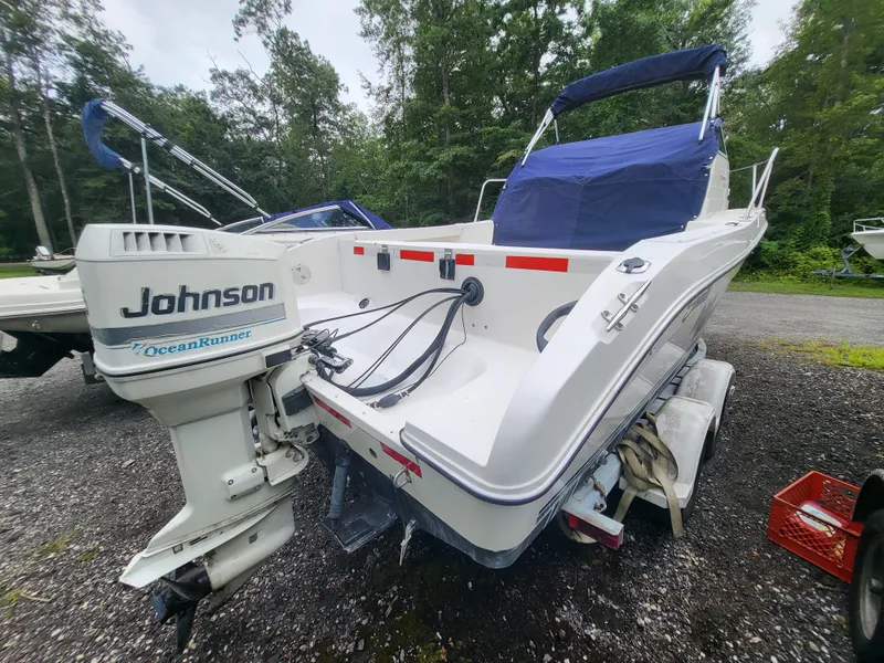 Slide: The Image of 1998 Seaswirl 2300 Walkaround boat with Johnson OceanRunner outboard motor, parked on a trailer. - 5