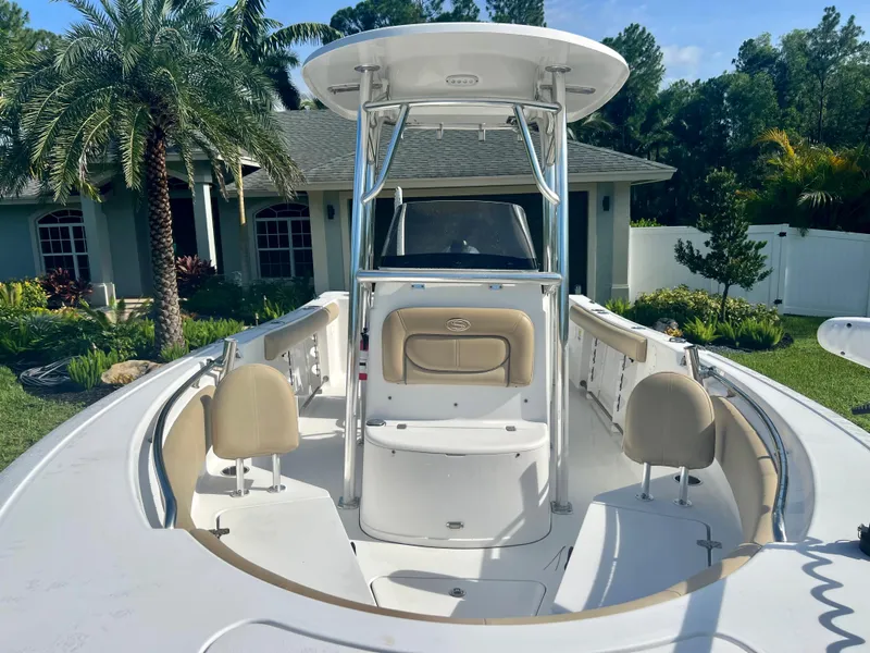 Slide: The Image of 2015 Sportsman 232 boat with seating and T-top in a residential backyard. - 12