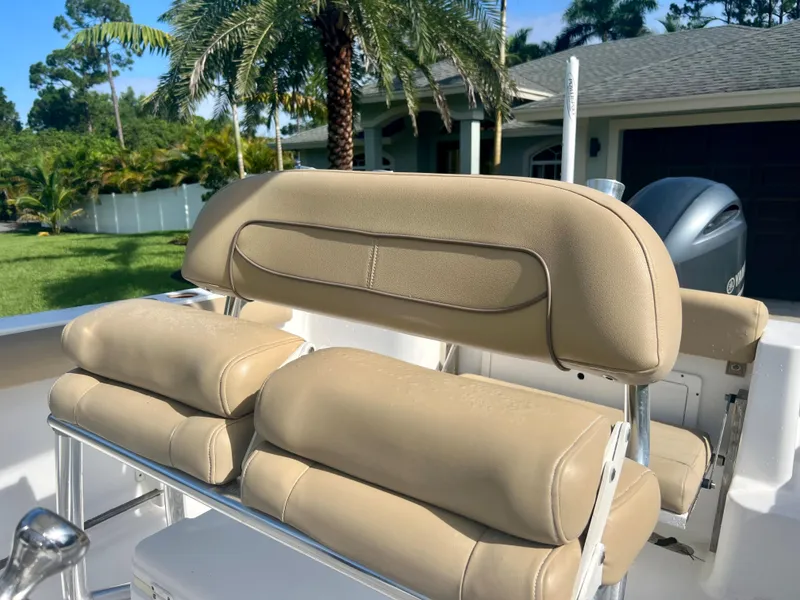 Slide: The Image of 2015 Sportsman 232 boat with beige cushioned seating and palm trees in the background. - 19