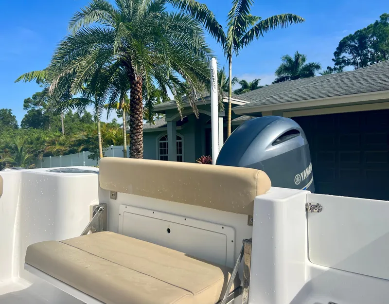 Slide: The Image of 2015 Sportsman 232 boat with Yamaha engine, beige seating, and palm trees in the background. - 20