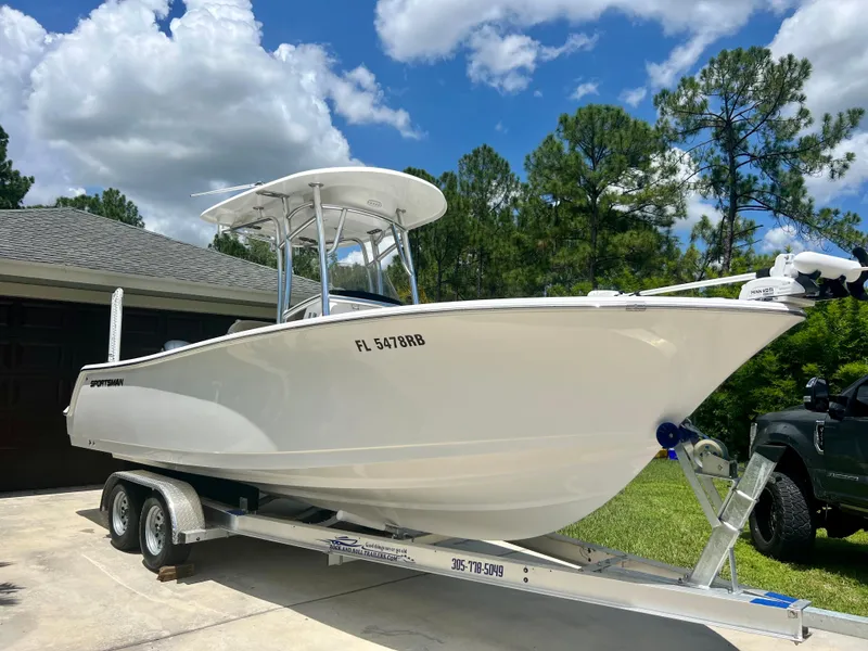 Slide: The Image of 2015 Sportsman 232 boat on trailer in driveway, clear sky background. - 5