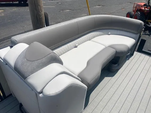 Slide: The Image of 2023 Avalon Catalina 2385 Quad Lounger boat seating area with gray and white upholstery. - 10