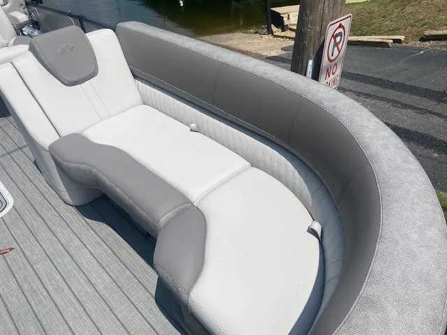 Slide: The Image of 2023 Avalon Catalina 2385 Quad Lounger boat interior with gray and white seating. - 23