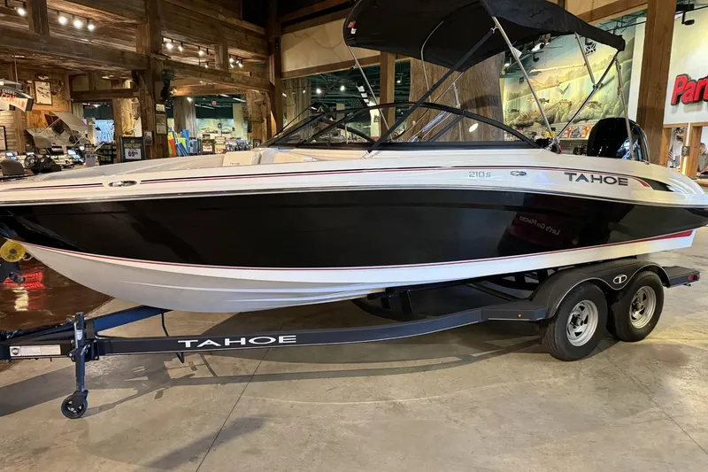 The Image of 2024 Tahoe 210 S boat on trailer in showroom setting. - 0