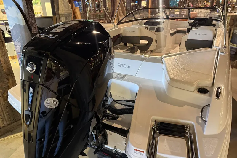 Slide: The Image of 2024 Tahoe 210 S boat with powerful outboard motor, sleek design, and spacious seating. - 2