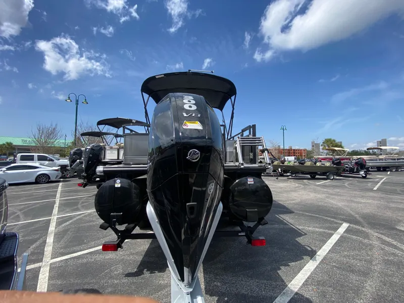 Slide: The Image of 2024 Regency 250 DL3 pontoon boat with a powerful 300 V8 engine in a parking lot. - 4
