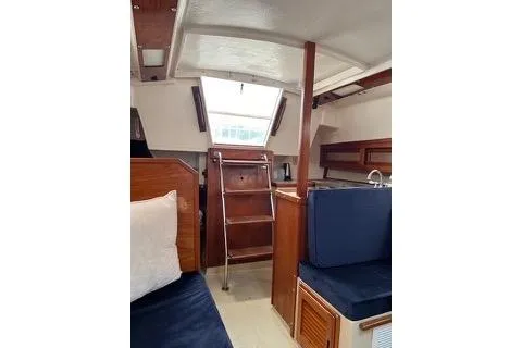 Slide: The Image of Interior of 1986 Laguna 30 sailboat with wooden finishes and blue seating. - 23