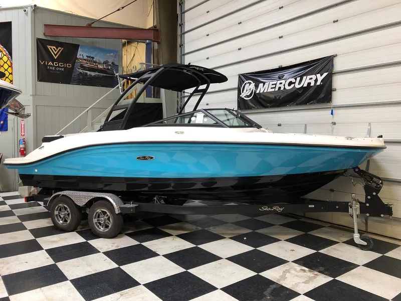 Slide: The Image of 2023 Sea Ray SPX 210 boat in showroom with Mercury banner. - 1