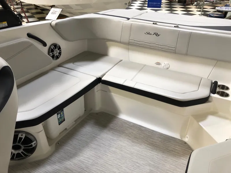 Slide: The Image of 2023 Sea Ray SPX 210 boat interior with white cushioned seating and built-in speakers. - 11