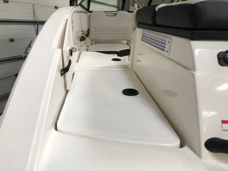 Slide: The Image of 2023 Sea Ray SPX 210 boat interior with white seating and storage compartments. - 3