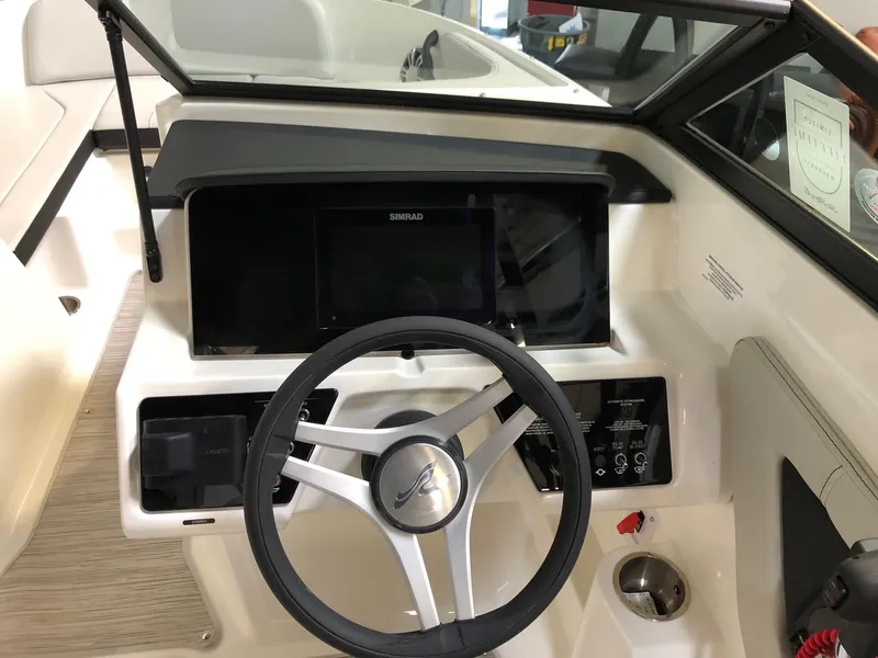 Slide: The Image of 2023 Sea Ray SPX 210 boat dashboard with steering wheel and control panel. - 9