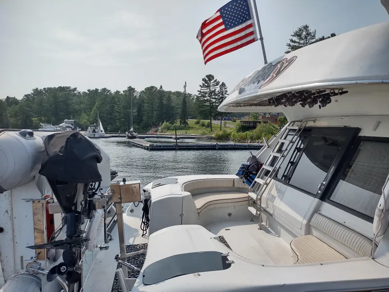 Slide: The Image of 1991 Bluewater Coastal Cruiser docked, American flag waving, serene marina backdrop. - 10