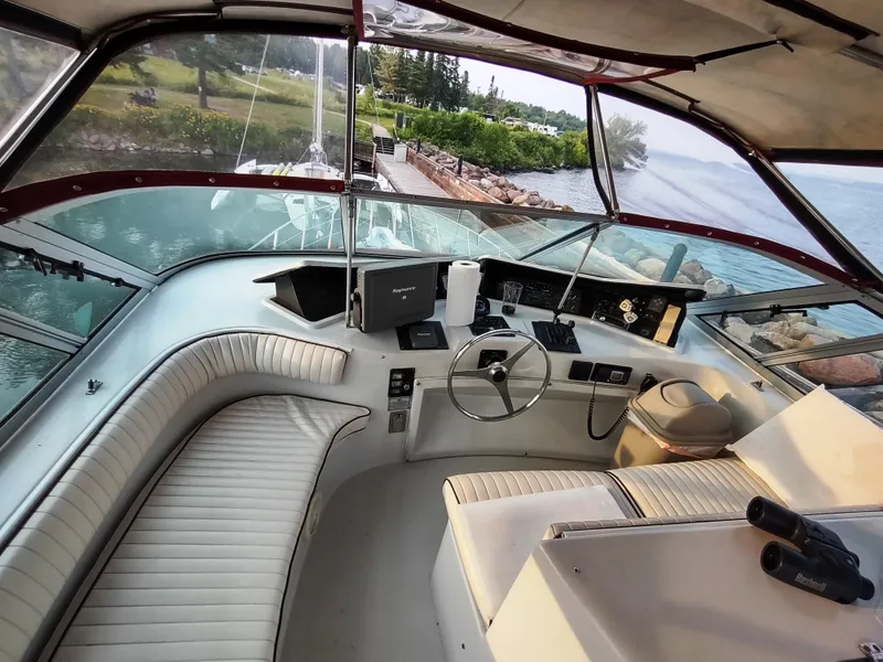 Slide: The Image of 1991 Bluewater Coastal Cruiser helm with panoramic view, featuring steering wheel and seating. - 15