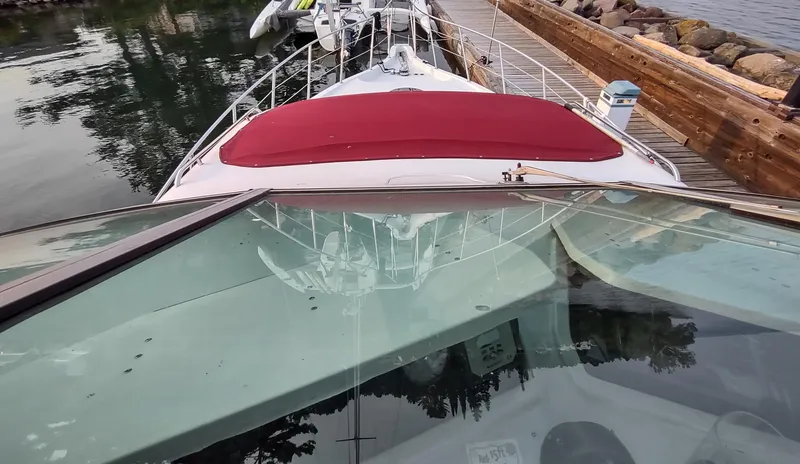 Slide: The Image of 1991 Bluewater Coastal Cruiser docked, featuring a red cover and glass windshield. - 18