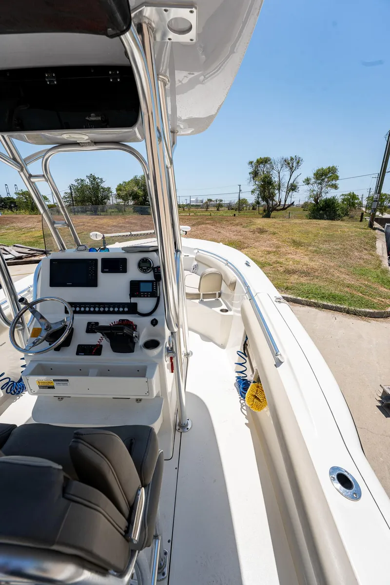 Slide: The Image of 2021 Key West 244 Center Console boat with modern dashboard and seating, docked outdoors. - 38