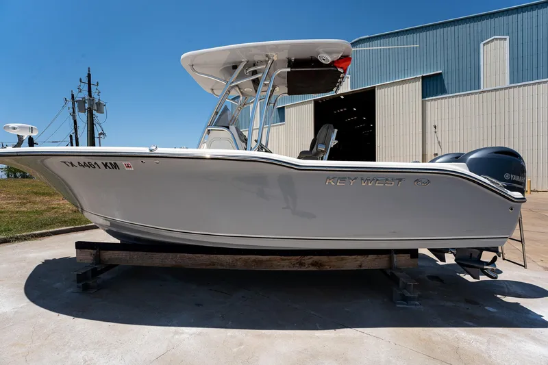 Slide: The Image of 2021 Key West 244 Center Console boat on trailer, parked outside a warehouse. - 5
