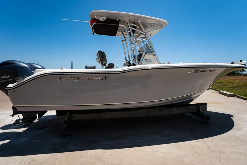 Slide: The Image of 2021 Key West 244 Center Console boat on a trailer under clear blue sky. - 7