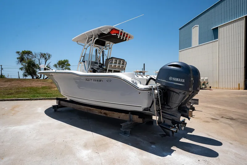 Slide: The Image of 2021 Key West 244 Center Console boat with Yamaha engine, parked outdoors. - 1