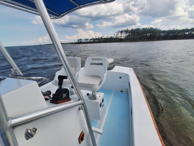 Slide: The Image of 2008 Custom Carolina boat on calm waters with a scenic shoreline in the background. - 21