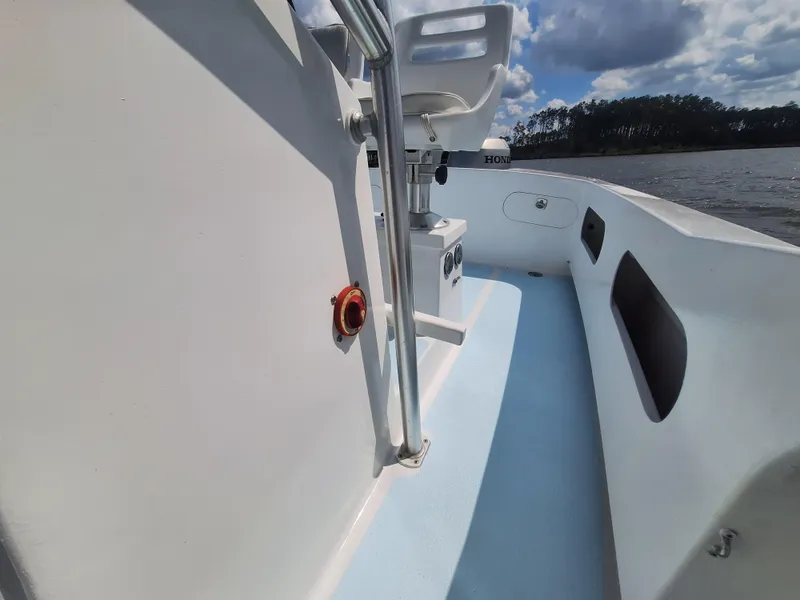 Slide: The Image of 2008 Custom Carolina boat interior with white seating and blue flooring. - 22