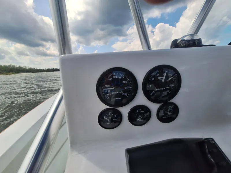 Slide: The Image of Close-up of 2008 Custom Carolina boat dashboard with gauges and water view. - 24