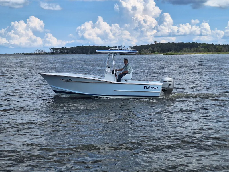 Slide: The Image of 2008 Custom Carolina boat cruising on a lake with a Honda outboard motor. - 3