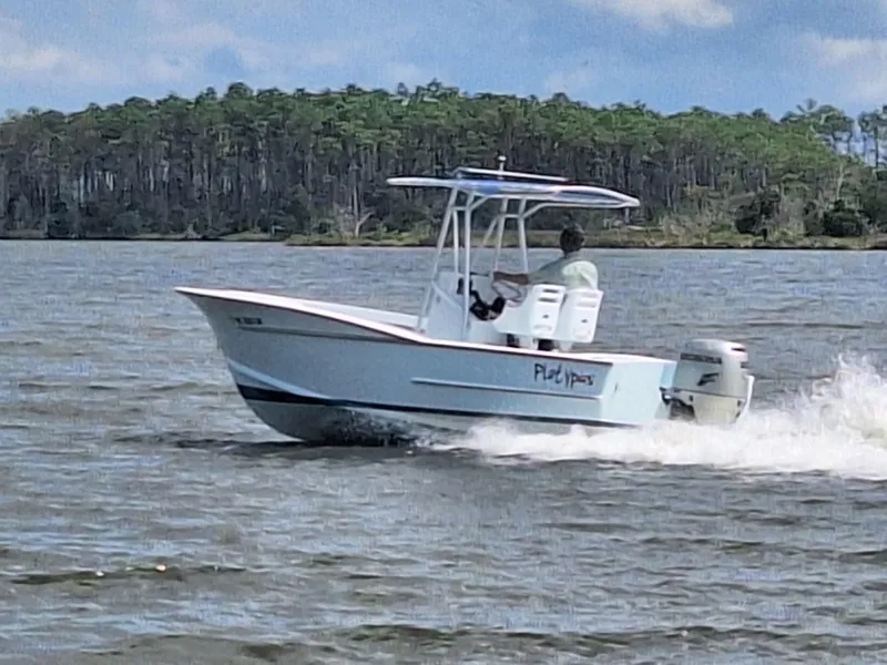 Slide: The Image of 2008 Custom Carolina boat cruising on a lake with forested shoreline in the background. - 5