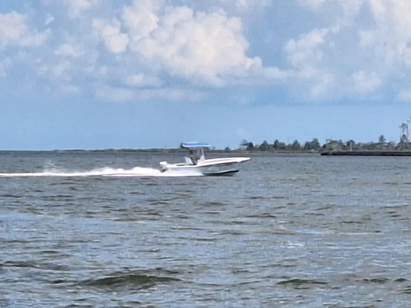 Slide: The Image of 2008 Custom Carolina boat speeding on open water under a partly cloudy sky. - 6